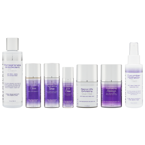 A collection of six skincare products from PinkBoxes Club designed for dry and sensitive skin, including Pomegranate Antioxidant Cleanser, Retinol 2% Exfoliating Scrub, Cucumber Hydration Toner, Ageless Skin Hydrating Serum, Hydrating Moisturizer, and Citrus-C Nourishing Cream. The products are arranged in a row with purple and white packaging featuring silver accents, highlighting their hydrating and nourishing benefits