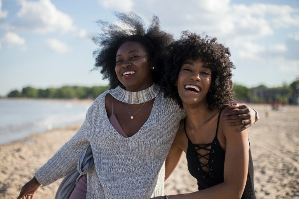 Two smiling black women on the beach